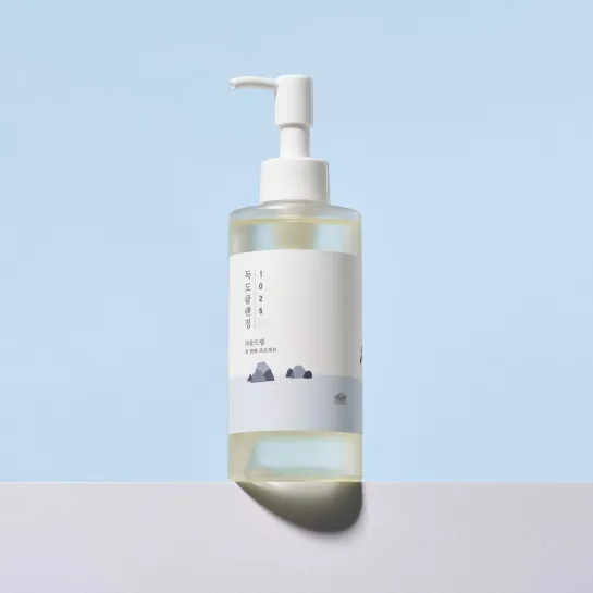 Clear bottle with pump dispenser, minimalist label, Korean text, pale blue background