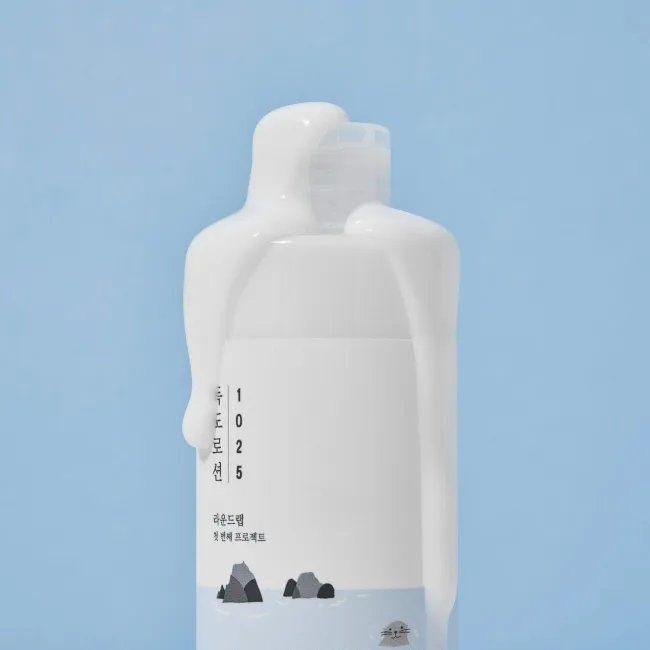 White skincare bottle with 1025 label and cute seal design on blue background
