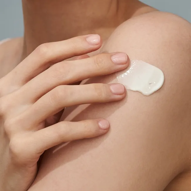 A close up of a woman applied BLACK RICE moisture airyfit daily sunscreen with SPF50+ PA++++ by haruharu wonder with very protection non-greasy, velvet finish on her body