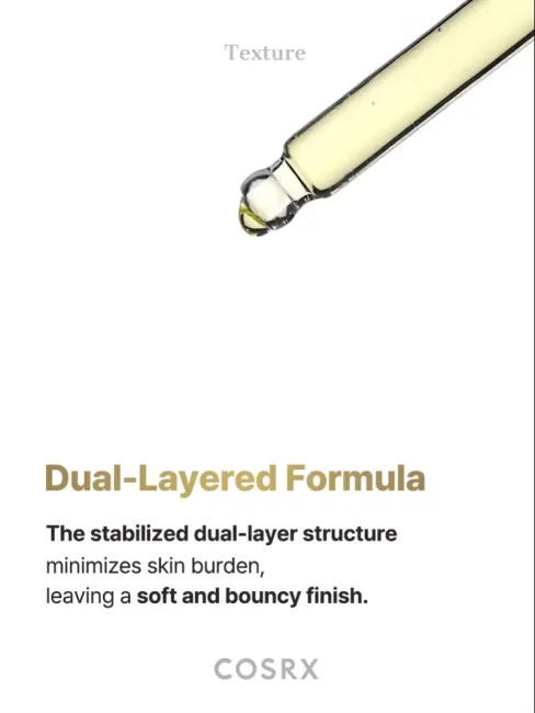 Close-up of COSRX Advanced The Vitamin C 23 Serum dropper with golden dual-layered formula; stabilized oil and water layers designed to minimize skin burden while delivering a soft, bouncy finish that hydrates and refines skin texture.