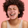 Pink peel-off mask applied on face, smiling model with product still visible