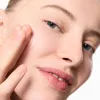 Model applying Niacinamide Serum to her face