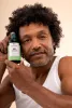 Man holding The Body Shop Aloe Soothing Toner 250 ML in light-colored studio setting