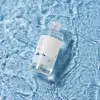 Clear skincare toner bottle in rippling water, showcasing clean beauty with natural ingredients