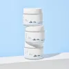 Stacked jars of clean Korean skincare cream with minimalist mountain design on labels