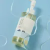 Korean skincare cleanser with pump dispenser, minimalist design, and clear liquid on blue background
