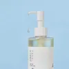 Clear skincare bottle with pump dispenser and droplet, minimalist design against blue background